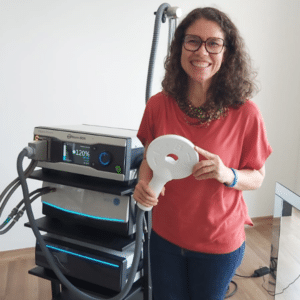 Dra. Eliza Reis segurando o equipamento de Estimulação Magnética Transcraniana para o tratamento da depressão